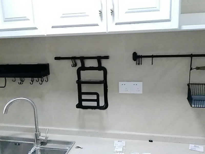 廚房五金掛件安裝：五金件的安裝一般是在瓷磚鋪貼完成后，在瓷磚上鉆孔，然后將木楔嵌入孔中，然后在上面用螺絲或膨脹螺絲將五金掛件進行固定。
掛件在使用過程中通常會承受一定重量，加上用力按壓、拽拉或安裝不牢固等，過段時間后，多少會出現(xiàn)松動、脫落的現(xiàn)象。在選購此類產(chǎn)品時，最好選擇帶有擋條的產(chǎn)品，確保上面的物品不會滑落傷人。另外，在使用前可查看其說明，注意其最大承受重量的限度，不要超重而引起安全隱患。