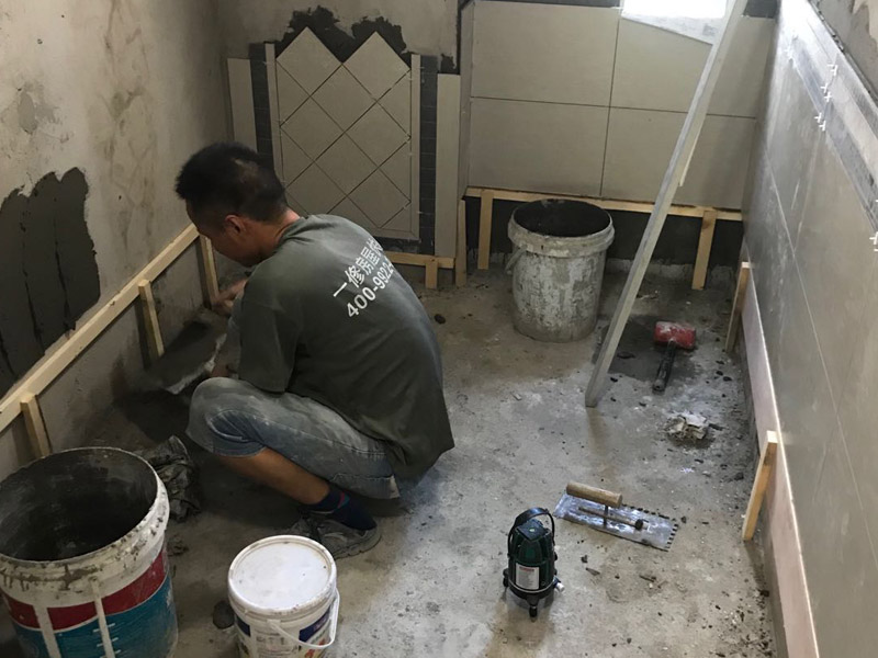 廁所瓷磚鋪貼裝修：首先應(yīng)除去基層表面的污垢，油漬，浮灰;除去基層上所有涂料層，膩?zhàn)訉?如果基層未能達(dá)到平整度要求，需對基層進(jìn)行預(yù)先的找平處理；鋪貼瓷磚前需事先找好垂直線，以此為基準(zhǔn)鋪貼的瓷磚高低均勻、垂直美觀;將調(diào)制好的漿料均勻地抹在瓷磚背面，要求漿料飽滿；將瓷磚平整地鋪貼在基層上，使用橡膠錘將瓷磚拍實(shí)鋪平。