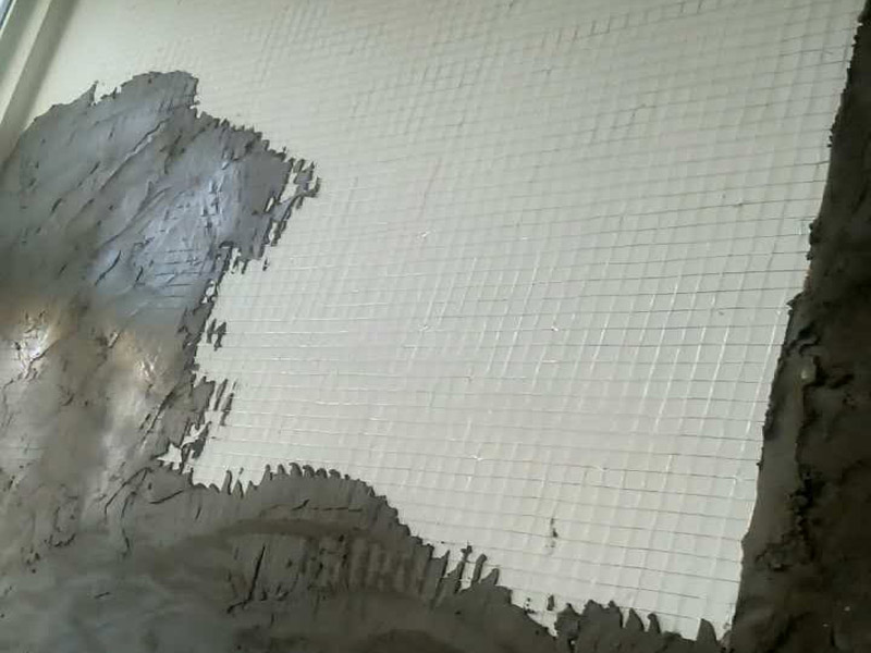 白灰墻面掛網(wǎng)抹灰裝修：1  基層處理：抹灰前檢查加氣混凝土墻體，對松動、灰漿不飽滿的拼縫及粱、板下的頂頭縫，用摻用水量10%的建筑膠灰漿填塞密實。將露出墻面的舌頭灰刮凈，墻面的凸出部位剔鑿平整。墻面坑凹不平處、砌塊缺楞掉角的以及剔鑿的設備管線槽、洞，應用膠灰整修密實、平順。2  灑水濕潤：將墻面浮土清掃干凈，分數(shù)遍澆水濕潤。由于加氣混凝土塊吸水速度先快后慢，吸水量慢而延續(xù)時間長，故應增加澆水的次數(shù)，使抹灰層有良好的凝結硬化條件，不致在砂漿的硬化過程中水分被加氣混凝土吸走。3  貼灰餅、沖筋：用托線板檢測一遍墻面不同部位的垂直、平整情況，以墻面的實際高度決定灰餅和沖筋的數(shù)量。