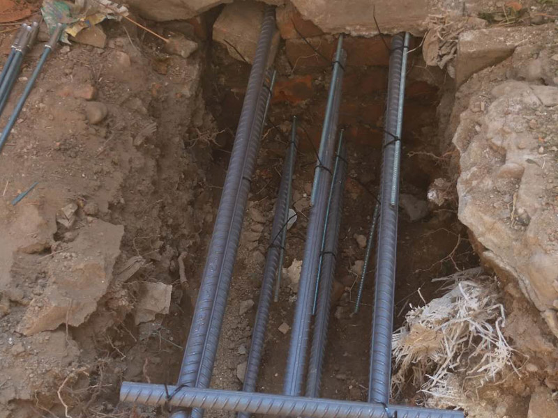 地面基層加固裝修：1.清理基層，清除磚柱上的管線和裝飾層，檢查柱根;別砌損壞的磚，清除 裂縫內(nèi)的粉塵。2.根據(jù)不同的加固形式，采用不同的連接措施，單側(cè)加固時，用混凝士釘或膨脹螺栓連接，雙面加固時，用封閉箍筋連接，當(dāng)柱較寬時，沿高度每隔5皮打掉一塊，增強(qiáng)混凝土與原柱的咬合，有利于共同受力。3.綁扎鋼筋:用外包鋼筋混凝土加固，綁扎的鋼筋應(yīng)與磚柱固定牢靠，控制好位置保護(hù)層厚度。4.澆筑混凝士:外包混凝士宜用噴射扶施工，具體步驟參照4.1節(jié)中噴射混凝土施工工藝流程:上部與樓板接縫，應(yīng)用干硬性混凝土填塞嚴(yán)實(shí);強(qiáng)度尊級符合勘察加固設(shè)計(jì)要求。5.將混凝t表面抹平壓實(shí)。6.待混凝土終凝后，每天澆水3~5次，進(jìn)行養(yǎng)護(hù)。