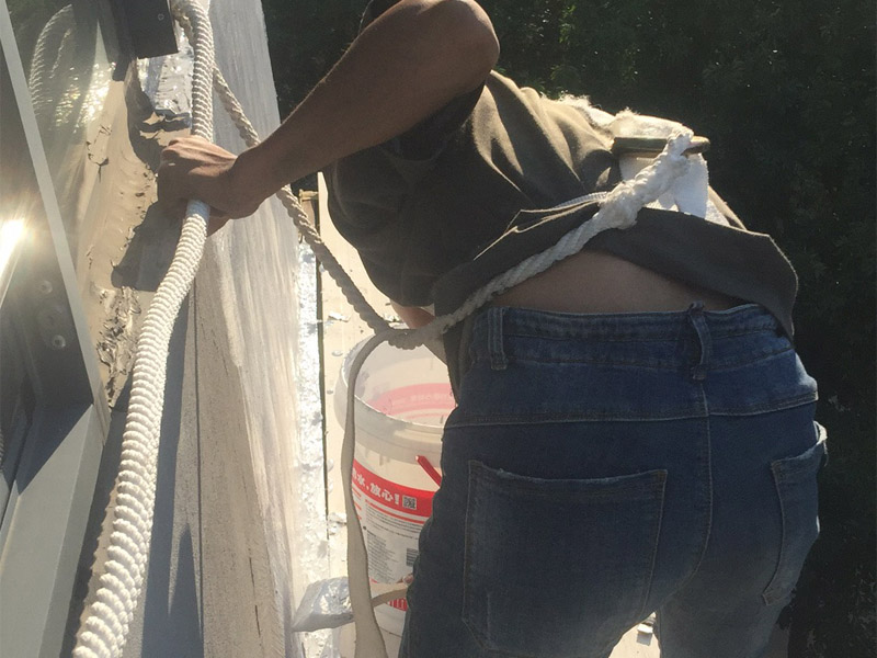 高空外墻粉刷裝修:1、基層處理：在對(duì)外墻粉刷之前，首先需要將墻面基層的灰塵與雜志清理干凈，那些比較破舊的層面與耐水性較差的涂層需要鏟除，如果表面有凹凸不平的地方，則需要用水泥砂漿進(jìn)行抹平。2、刷底膠：在對(duì)墻面刷底膠時(shí)，需要先將膠水按照說(shuō)明書(shū)上注明的比例進(jìn)行稀釋?zhuān)♂尯弥?，再將膠水用輥筒均勻涂刷墻面兩遍左右，注意膠水的薄厚要均勻，不能過(guò)多也不能過(guò)少。3、局部補(bǔ)膩?zhàn)樱夯鶎拥啄z干燥之后，則需用膩?zhàn)訉γ嬲移健?、滿(mǎn)刮膩?zhàn)樱耗佔(zhàn)臃旁谕邪逯希尯笤儆孟鹌す伟鍖?duì)墻面進(jìn)行涂刷，最好從上往下涂，最好涂刷2到三遍，需要注意的是，膩?zhàn)硬荒芡克⑻?，膩?zhàn)油克⒑笮枰蒙凹堖M(jìn)行打磨，打磨力度需要合適，打磨完之后需要將表面灰塵給清除。5、刷底涂料：采用滾筒對(duì)墻面涂刷，涂刷時(shí)需要均勻，不能漏刷，也不能刷得過(guò)厚，底料干后，如果表面有要進(jìn)行修補(bǔ)的地方，最好用膩?zhàn)舆M(jìn)行修復(fù)在進(jìn)行砂平。