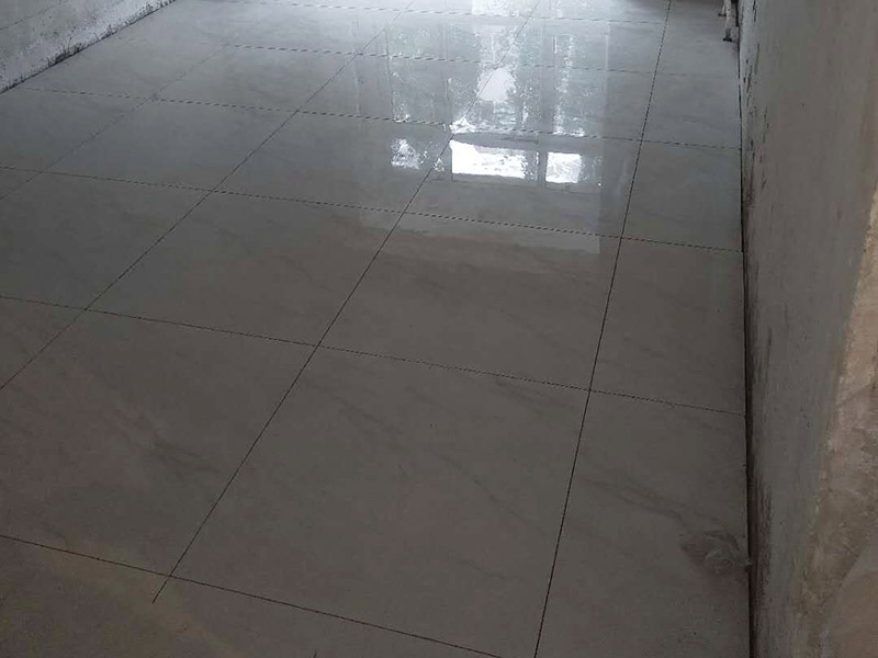 客廳地磚鋪貼裝修：首先將沙子和水泥按照3：1的比例混合后兌少量的水，使水泥和沙子混合到可以用手攥成團的黏稠度；接著在鋪磚之前先將要鋪的地方用水潑濕。將開始和好的水泥和沙子鏟到你要鋪瓷磚的地方，鏟完以后用小鏟子初步抹平。然后瓷磚背后抹上開始和好的那盆比較稠的水泥漿，再將抹好水泥的磚小心平放到要鋪的地方，注意對縫。再用橡膠小榔頭敲實，用水平尺找平。最后在側邊用小榔頭的把手堵嚴實，完工。