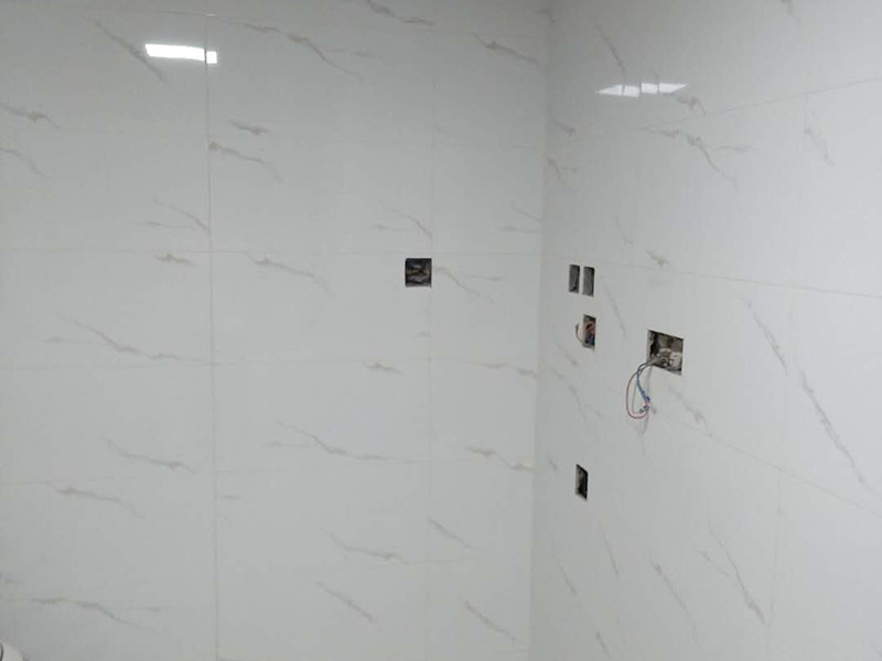 衛(wèi)生間瓷磚鋪貼：基層處理：把沾在基層上的浮漿、落地灰等用暫子或鋼絲刷清理掉，再用掃帚將浮土清掃干凈。找標(biāo)高：根據(jù)水平標(biāo)準(zhǔn)線和設(shè)計(jì)厚度，在四周墻、柱上彈出面層的上平標(biāo)高控制線。排磚：將房間依照磚的尺寸留縫大小，排出磚的放置位置，并在基層地面彈出十字控制線和分格線。鋪設(shè)結(jié)合層砂漿：鋪設(shè)前應(yīng)將基底濕潤(rùn)，并在基底上刷一道素水泥漿或界面結(jié)合劑，隨刷隨鋪設(shè)攪拌均勻的干硬性水泥砂漿。鋪磚時(shí)應(yīng)先在房間中間按照十字線鋪設(shè)十字控制磚，之后按照十字控制磚向四周鋪設(shè)，并隨時(shí)用2m靠尺和水平尺檢查平整度。大面積鋪貼時(shí)應(yīng)分段、分部位鋪貼。養(yǎng)護(hù)：當(dāng)磚面層鋪貼完24h內(nèi)應(yīng)開(kāi)始澆水養(yǎng)護(hù)，養(yǎng)護(hù)時(shí)間不得小于7d。