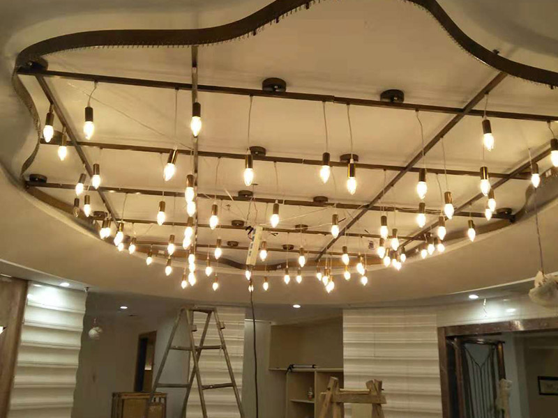 大型吊燈安裝：首先大致尺寸要測量好，確定位置；然后石膏板上鉆孔，然后埋設(shè)鐵件五金配件或者木條，用黏貼劑或者水泥漿將空洞的周邊補(bǔ)齊，等到差不多干燥了再接下來做。接著把鐵件或者木條固定，這是吊燈安裝的重要步驟，如果沒有固定好，使用壽命會受到影響。電線通過吊桿引入到燈芯里面，如果配套燈帶使用開關(guān)的，穿線的時(shí)候要注意線路的走向。最后就是燈罩、燈臂的安裝。用看、螺絲刀等工具將燈罩組裝好，安裝好后，通電試試就可以了，根據(jù)實(shí)際情況稍微調(diào)整下。