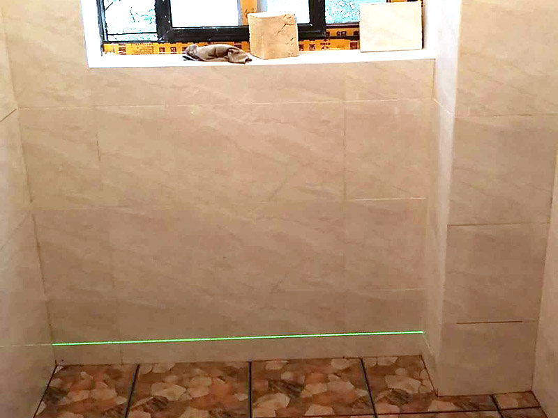 衛(wèi)生間瓷磚鋪貼：基層處理：首先應(yīng)除去基層表面的污垢，油漬，浮灰;除去基層上所有涂料層，膩子層;如果基層未能達(dá)到平整度要求，需對基層進(jìn)行預(yù)先的找平處理。  放樣：鋪貼瓷磚前需事先找好垂直線，以此為基準(zhǔn)鋪貼的瓷磚高低均勻、垂直美觀;此外，施工前在墻體四周需彈出標(biāo)高控制線，在地面彈出十字線，以控制地磚分隔尺寸。  預(yù)鋪：首先應(yīng)對瓷磚的色彩、紋理、表面平整等進(jìn)行嚴(yán)格的挑選，然后按照圖紙要求預(yù)鋪。 調(diào)制粘結(jié)劑：加水后將粘結(jié)劑漿料攪拌至潤滑均勻，無明顯塊狀或糊狀結(jié)塊，攪拌后的漿料靜置5-10分鐘后再稍加攪拌1-2分鐘即可使用。在開始鋪貼施工前，需要先清理瓷磚表面的浮灰，污垢等。  抹漿料：將調(diào)制好的漿料均勻地抹在瓷磚背面，要求漿料飽滿。將瓷磚平整地鋪貼在基層上，使用橡膠錘將瓷磚拍實鋪平。施工過程中，可小幅度轉(zhuǎn)動瓷磚，使?jié){料與瓷磚背面充分接觸。 瓷磚鋪貼結(jié)束后24小時，可進(jìn)行嵌縫施工。將調(diào)制好的嵌縫劑均勻地涂在磚與磚的縫隙內(nèi)。嵌縫后用浸濕的織物清理多余的嵌縫劑，保持瓷磚表面清潔。