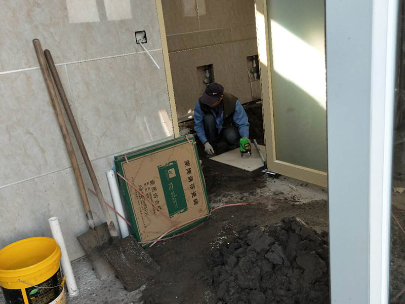 公廁貼磚維修：基層處理：應全部清理墻面上的各類污物，打掃干凈現(xiàn)場，特別是腳落里。 批墻、墻面找平：用泥刀先批墻，后用水泥漿找平。這個工序很重要，確保底子平，防止貼后空鼓。 刷防水涂料：墻面要刷防水涂料，防止貼后浸水，一般高度不低于1.8米，刷的時候會稍高一些。 找水平基準線：根據(jù)設(shè)計鋪貼圖樣的要求，確定排磚方案，用墨斗彈線，以減少施工損耗。 粘結(jié)劑上墻：把剛剛攪拌好的粘結(jié)劑漿料均勻的刮到墻上。 瓷磚上墻將經(jīng)過預先清潔的瓷磚平整地鋪貼在粘結(jié)劑漿料基層上，使用橡膠錘將瓷磚拍實鋪平。施工過程中，可小幅度轉(zhuǎn)動瓷磚，使?jié){料與瓷磚背面充分接觸。專家建議在鋪貼時，隨機取下已鋪貼于基層上的瓷磚作檢查。確保漿料與瓷磚背面的充分接觸。 留縫大小調(diào)整根據(jù)瓷磚的尺寸，在磚與磚之間預留相應尺寸的縫隙留待嵌縫?？捎醚篮灥认裙潭ǎ辰Y(jié)劑具有一定的可調(diào)整性，可對留縫的大小進行調(diào)整。