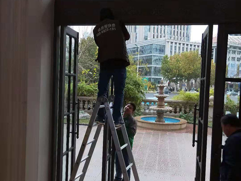 室外門維修：首先安裝門框，這個門檻是事先量好尺寸制作好的。把門框靠在門洞里，一般是安裝門扇的那邊靠墻。并使用沖擊鉆鉆孔，安裝2只膨脹螺絲。然后打安裝孔，使用膨脹螺絲穿過門框，在門框的后面適當(dāng)?shù)募尤?個斜頭木楔，并使用卷尺量好同樣的寬度，通過調(diào)節(jié)斜頭木楔的長短達(dá)到合適的寬度。緊固好2只膨脹螺絲后就可以把門扇放入門框里，查看尺寸是否合適。并安裝門框上的合頁。把合頁對好位置，并使用鉚釘槍打入鉚釘，固定合頁，然后再在合頁上打第二個孔和安裝鉚釘。同樣的步驟安裝好門框下的合頁。完成2只合頁的安裝后就把門扇放入門框里，以合頁的安裝位置為基礎(chǔ)，移動門扇，達(dá)到最佳安裝位置。如果門扇短一些，就可以在門扇底部墊斜頭進(jìn)行支墊。位置合適后使用記號筆做好合頁螺絲安裝孔位置。再使用手槍鉆鉆孔和使用鉚釘槍加入鉚釘。打開門查看移動是否靈活，再完成剩下的孔的鉚釘安裝。