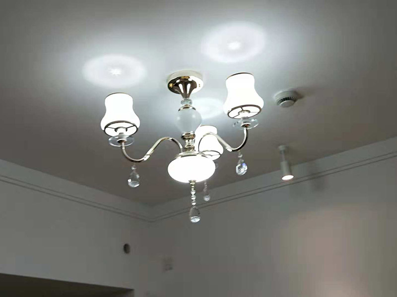 吊燈安裝：一、確定位置  吊燈位置確定之后，還要注意檢測該位置的承重力，畢竟一盞吊燈的重量還是蠻重的，尤其是客餐廳吊燈又大又重，倘若頂面承重力不夠，時間長了會有脫落的危險。所以吊燈安裝位置應是實心磚石頂面或墻面，不宜是輕質(zhì)木質(zhì)頂面。 步驟二、拆吊燈面罩  吊燈面罩會有旋轉(zhuǎn)式和卡扣式兩種固定方式，大家拆卸時要小心謹慎，不要弄壞吊燈了。面罩和燈管都要取下來，以免安裝的過程中碰碎燈管。 三、安裝底座  將吊燈底座對著頂面或墻面的安裝位置，找到孔位并標記出來，然后放下底座，使用與孔位規(guī)格相同的電鉆來打孔，天花板孔位一般是在6毫米，打孔完畢后就可以安裝膨脹螺栓了，這是固定吊燈底座用的，不過要注意孔的深度，要把膨脹螺絲塞入孔內(nèi)，使用錘子把它敲進去，之后將底座與膨脹螺栓擰緊、固定，要與預先確定的安裝位置相同，不能有偏移的情況。 四、連接燈線   吊燈底座固定后，就可以連接燈線與電源線了，不過要注意連接的兩個線頭要接觸良好，需用黑膠布包裹好，并注意保持間距，盡量不把兩個連接頭放在一塊金屬片下，防止產(chǎn)生短路帶來危險。連接好燈線與電源線后就可以安裝燈管，這時可通電檢查，看看能否正常使用，如不正常要檢查線路，若一切OK，那么就要關閉電源再繼續(xù)吊燈后續(xù)安裝。