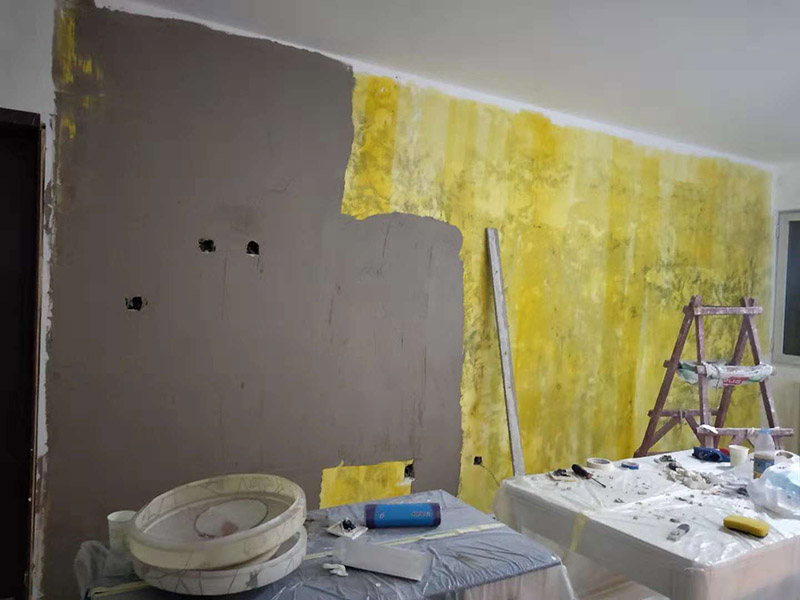 客廳墻面改造：在施工之前，首先要對墻面進行清理，確?；鶎拥钠秸饣⒒鶎颖砻孢M行完全清除，做到墻面無灰塵，再進行界面劑的施工，涂刷厚度應均勻，這樣做的目的是將基層完全密閉住，同時增加著附力。然后對墻面進行找平處理，可以通過專門檢測工具來進行平整度的確定，如果存在不平的地方，應使用石膏來進行補平。然后在進行刮膩子的施工步驟，一般刮完兩遍即可，如果不太平整的區(qū)域需要多刮幾次，每次膩子施工，應進行充分的間隔。當膩子刮好后，接著就需要進行油漆的施工，最先上底漆，目的主要是提高墻面的防水防潮性，還增加面漆的粘結效果。等墻面完全干透后，還需進行打磨的處理，使用細砂紙將墻面一一打磨，這樣會讓墻面看起來更平滑。在施工中，可以用手觸摸，感受下墻面的光滑感。