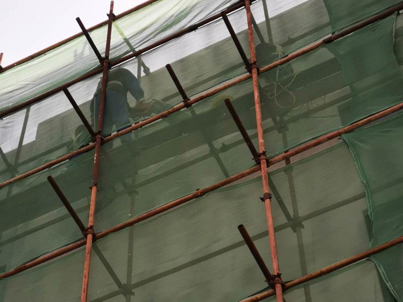 高空外墻防水：首先清理基層，新舊面層必須清理干凈，不得有雜物和灰塵，以免影響粘結(jié)強度，涂刷防水涂料時基層應(yīng)干燥。接下來，清理死角，也就是所謂的陰陽角、施工縫、伸縮縫等比較重要的部位進行處理，尤其注意的是泄水孔要加強處理，需要涂刷2-3遍防水底層涂料。備好防水卷材、防水涂料、基層涂料和粘接卷材的涂料必須要分清，為提高防水卷材與基層粘結(jié)性，可用底層涂料反復(fù)涂刷，涂刷均勻，覆蓋完全，充分滲入混凝土基層，以提高粘結(jié)強度和抗剪切強度。涂刷第二次涂料之前必須要等第一次涂料完全凝固后方可再次涂刷，底層涂料第一次涂刷完畢后約4-8小時左右，方可再次涂刷第二次和第三次底層涂料。