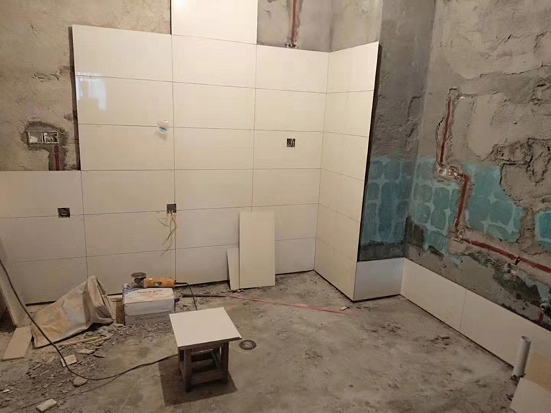 浴室墻面貼瓷磚：貼瓷磚之前先要用水浸泡瓷磚2小時(shí)左右。泡水的目的是為了讓瓷磚能事先吸飽水分，避免鋪貼之后吸走粘接材料中的水分，從而影響粘接的強(qiáng)度，浸水后記得用棉布擦去表面的水分晾干后才能進(jìn)行鋪貼。鋪貼開始前還應(yīng)吊垂線，來確定瓷磚的尺寸線，然后開始貼瓷磚，一般都是從門窗先開始，而且按由下而上，自左至右的順序進(jìn)行。鋪貼的方法是先用水潤濕找平層，然后用鏟子將事先拌好的粘接材料抹在瓷磚背面，再將瓷磚貼在墻上即可，依次鋪貼平整就可以了。