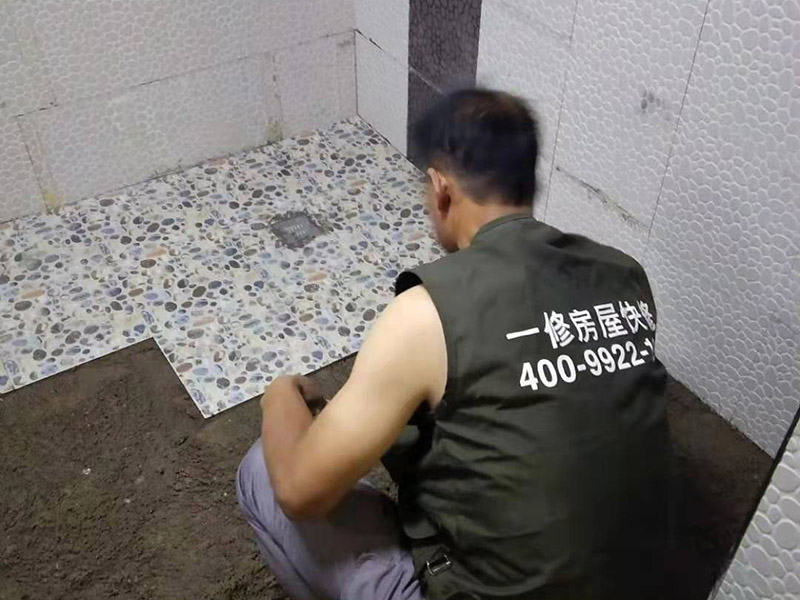 衛(wèi)生間地面花磚鋪貼:找平，就是在鋪仿古磚前，對(duì)鋪貼物表面進(jìn)行處理，如地面、內(nèi)墻面、外墻面等，消除表面附著的污物，并灑水進(jìn)行滋潤(rùn)，然后用水泥沙混合找平，通常使用灰鏟在表面不停的涂抹使水泥地面保持大致水平，一定要等到水泥沙混合物完全干爽后再行鋪貼。用一段較長(zhǎng)的細(xì)線，根據(jù)確定的鋪貼方式，在線上涂上顏色或白灰，然后在找平的地面上畫(huà)出仿古磚的位置及磚縫的參考線。 將亞光磚置入清水中浸泡，使瓷磚充分吸收水分，以不冒出氣泡為準(zhǔn)，防止干燥瓷磚在裝修完成后再次吸水而導(dǎo)致磚體變形。取出浸泡好的瓷磚，抹干水漬，在找平層上噴灑足夠的水，然后在磚背面均勻抹上水泥沙漿，沙漿厚度5~6cm為宜，鋪貼大規(guī)格亞光磚時(shí)適當(dāng)加厚；隨即將磚貼上，用木錘輕輕拍牢平整，避免空鼓，并隨時(shí)用直尺找平。