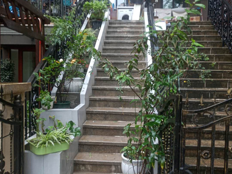 戶外樓梯加花壇：用測量儀器把花壇群中主花壇中心點(diǎn)坐標(biāo)測量到地面上，再把縱橫中軸線上的其他中心點(diǎn)的坐標(biāo)測設(shè)下來，將各中心點(diǎn)連線，即在地面上放出花壇群的縱橫軸線。放線完成后，應(yīng)沿著已有的花壇邊線開挖邊緣石基槽。基槽的開挖寬度應(yīng)比邊緣石基礎(chǔ)寬10厘米左右，深度可在12～20厘米之間。槽底土面要整平、夯實(shí)，有松軟處要進(jìn)行加固，不得留下不均勻沉降的隱患。在砌基礎(chǔ)之前，槽底還應(yīng)做一個3～5厘米厚的粗砂墊層，用于基礎(chǔ)施工找平。