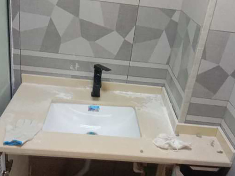 臺盆五金安裝：1.檢查預留給排水管路，安裝支撐洗面盆臺面的鋼制支架。 2.根據臺下盆包裝箱內的臺面切割圖將臺面開孔打磨完畢。 3.按照安裝的龍頭和臺面尺寸正確切割龍頭安裝孔，打磨。 4.把洗面盆暫時放入已開好的臺面安裝口內，檢查間隙，并做好記號。 5.檢查校驗后，把洗面盆放平，在洗臉盆邊緣上口涂上硅膠密封材料后，把洗面盆小心放入臺面下，對準安裝孔，跟先前的記號相校準并向上壓緊，并使用廠家隨貨附帶的臉盆與臺面的連接件，將洗臉盆與臺面緊密連接。 6.臺下盆邊緣打膠。 7.安裝臺下盆上下五金件。 8.等密封膠硬化后，連接進水和排水管件。