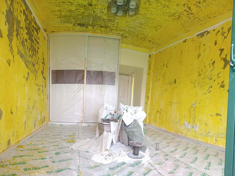 墻面基層刷防固漆：首先我們要把墻體上的工業(yè)大白鏟掉，這種工業(yè)大白是開發(fā)商為了交房刷的一層膩?zhàn)臃?，它會遮蓋空鼓裂縫，所以我們需要鏟掉，然后做基層處理，主要是處理空鼓和裂縫，空鼓用錘子敲開然后用水泥砂漿填平，裂縫就用嵌縫帶嵌上。接著刷一層界面劑，這個(gè)界面劑就是黃墻綠地的效果，可以稱為墻固地固，一般毛坯墻中都會含有工業(yè)氨水，而它會持續(xù)不斷的釋放一種有害氣體--氡氣，這個(gè)氡氣對我們的呼吸道和關(guān)節(jié)有一定的危害，所以界面劑一個(gè)作用就是為了防止墻體中的氡氣進(jìn)入室內(nèi)。也可以增加墻面和膩?zhàn)拥母街?，增?qiáng)刷漆質(zhì)量。地固的話可以防止工地灰塵煙塵太大，會影響工人施工，另外也可以防止灰塵附著在某些家具表面，影響后期家具漆的效果。