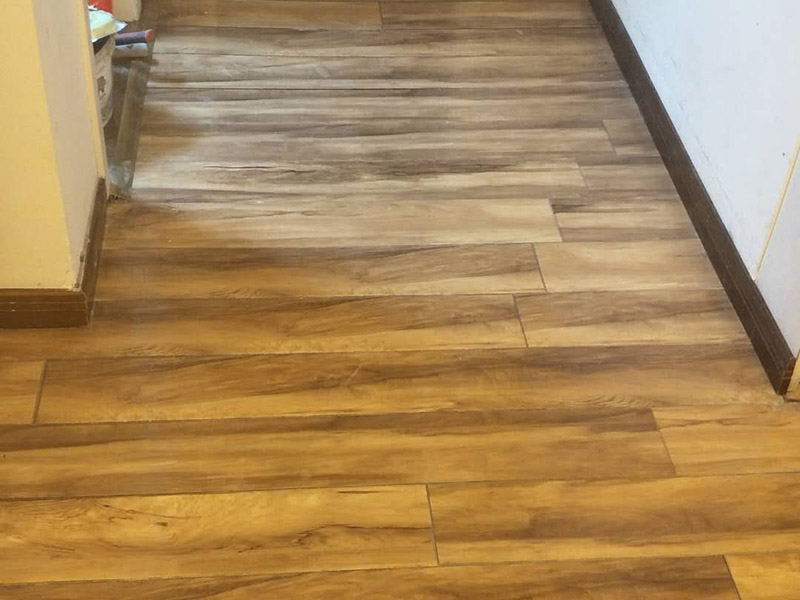 入戶門鋪地板：1、先對地面進(jìn)行找平，水平的誤差不能超過2毫米。地面要是不平，腳感就不好。再就是將邊、角部位等突起或有不平的地方進(jìn)行局部修整。再鋪防潮層，防潮層可以防止以后地板受潮。鋪平，接縫處要并攏。  2、然后就是安裝地板了，因為地板是要錯落安裝的，先預(yù)鋪一下，將部分地板一分為二，要按尺寸來鋸，萬一鋸多了，地板損耗就大了。因為地板有一定的膨脹率，因此鋪裝前要在其與墻面接觸的部位預(yù)留膨脹縫，以免地板起鼓。膨脹縫的大小一般和地板的膨脹系數(shù)有關(guān)系。粘合地板的膠水要用強(qiáng)化地板專用的，這種膠的污染比較小。不要隨便在市場上選非地板專用膠，地板本身就存在的污染上再增加污染源。  3、鋪前看好地板是否用對，再鋪設(shè)地板。在鋪設(shè)時，要一塊短的旁邊鋪一塊長的，這樣交叉鋪設(shè)地板就咬得住不易松動，地板拼合后還要用工具敲緊。再下來就是銜接了，一般用地板壓條掩蓋。但也有用玻璃膠填充。