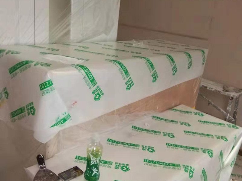 全屋家具成品保護：滿鋪成品瓦楞紙板，再用干凈彩條布滿鋪在普通石膏板上，在彩條布交接處及轉(zhuǎn)角處用膠帶固定，也可選用木芯板或三夾板。材料選用視上人、車情況而定。 所有成品飾面板在安裝好后必須用PE保護膜覆蓋包起來，所有成品飾面板的陽角位必須用硬質(zhì)紙護角或泡沫棉進(jìn)行保護性包裝，防止交被其他施工人員碰撞。 1、入戶門扇用公司統(tǒng)一的門貼進(jìn)行全面包裹保護，用透明膠帶將保護膜粘貼牢固平整。 2、用標(biāo)準(zhǔn)保護膜將門框三面保護完整并固定牢固。 3、工程完工后拆除保護膜時如果有粘貼時的膠痕，應(yīng)用酒精或?qū)Ｓ玫那逦蹌┣宄z痕。