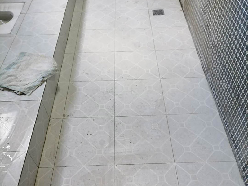 公共衛(wèi)生間貼磚施工：清理墻面上的各類污物，打掃干凈現(xiàn)場，特別是腳落里。用泥刀先批墻，后用水泥漿找平。這個(gè)工序很重要，確保底子平，防止貼后空鼓。墻面要刷防水涂料，防止貼后浸水，一般高度不低于1.8米，刷的時(shí)候會(huì)稍高一些。瓷磚上墻將經(jīng)過預(yù)先清潔的瓷磚平整地鋪貼在粘結(jié)劑漿料基層上，使用橡膠錘將瓷磚拍實(shí)鋪平。施工過程中，可小幅度轉(zhuǎn)動(dòng)瓷磚，使?jié){料與瓷磚背面充分接觸。留縫大小調(diào)整根據(jù)瓷磚的尺寸，在磚與磚之間預(yù)留相應(yīng)尺寸的縫隙留待嵌縫。可用牙簽等先固定，粘結(jié)劑具有一定的可調(diào)整性，可對(duì)留縫的大小進(jìn)行調(diào)整。