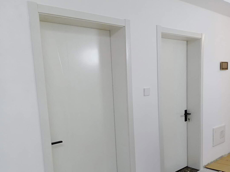 臥室套裝門安裝：到工地后，先清理干凈門洞及安裝現(xiàn)場，測量好門洞尺寸，再心中計劃好安裝方式，把門扇尺寸測量好，門頂板一般比實際門洞尺寸長20-50 mm、裝門空隙6-8mm，用門頂板以門扇現(xiàn)場尺寸一邊釘2顆釘，把門框固定，把門洞的上下對角也用手唑打平。門框左右兩邊各釘四片拉片，把門框放入門洞內(nèi)，頂板中間前后各釘2片拉片。把門框放入門洞中央，兩邊分均勻，并用木屑把兩邊門框跟門洞之間的空隙，把合頁裝上門扇，注意好門扇與門框的平整度（留好線條位置），把門扇裝在固定的門框上，關(guān)好門，試好能否開關(guān)自如，門頂板是否合適，另一邊板上下是否合線，用木屑墊平門框，全部固定再試好門扇是否關(guān)開自如。