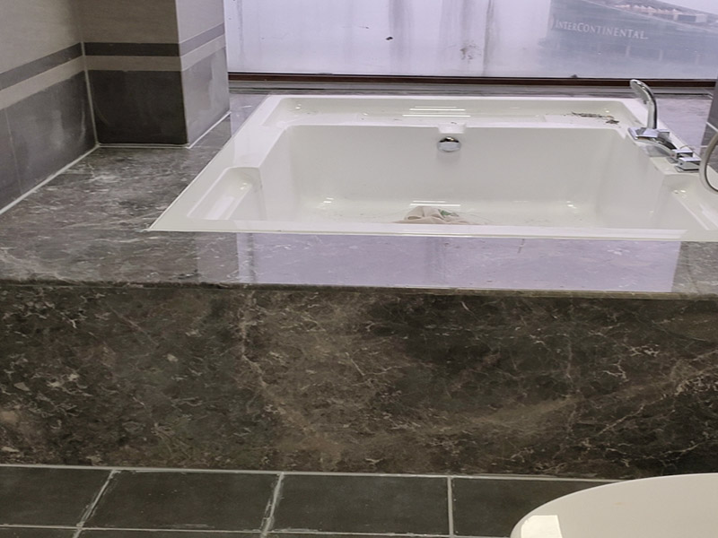 浴缸貼磚安裝：在安放浴缸時(shí)注意下水口的另一端要略高于下水口的一端，以便將來排污不暢。這一點(diǎn)要因情況而定。一般正常的浴缸底部本來就留出了排水的坡度。在安放浴缸時(shí)注意下水口的另一端要略高于下水口的一端，以便將來排污不暢。這一點(diǎn)要因情況而定。一般正常的浴缸底部本來就留出了排水的坡度。浴缸裙的貼磚是不需要抓毛的，砌好紅磚的臺子，在表面抹一層水泥砂漿，然后等兩天再來貼磚即可，貼磚很麻煩，由于地面留了坡度，而浴缸是平的，所以每一塊大磚都要打磨成不同的尺寸，不可以一次打磨很多，容易磨多了，要反復(fù)磨。磚的上邊要塞入浴缸的圓邊下，這樣才不會(huì)形成陽角。