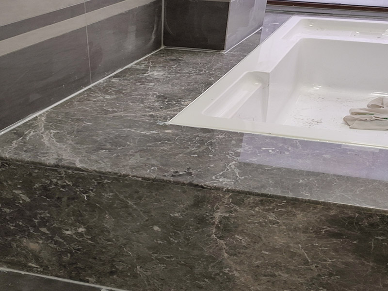 浴缸貼磚安裝：在安放浴缸時(shí)注意下水口的另一端要略高于下水口的一端，以便將來排污不暢。這一點(diǎn)要因情況而定。一般正常的浴缸底部本來就留出了排水的坡度。在安放浴缸時(shí)注意下水口的另一端要略高于下水口的一端，以便將來排污不暢。這一點(diǎn)要因情況而定。一般正常的浴缸底部本來就留出了排水的坡度。浴缸裙的貼磚是不需要抓毛的，砌好紅磚的臺子，在表面抹一層水泥砂漿，然后等兩天再來貼磚即可，貼磚很麻煩，由于地面留了坡度，而浴缸是平的，所以每一塊大磚都要打磨成不同的尺寸，不可以一次打磨很多，容易磨多了，要反復(fù)磨。磚的上邊要塞入浴缸的圓邊下，這樣才不會(huì)形成陽角。