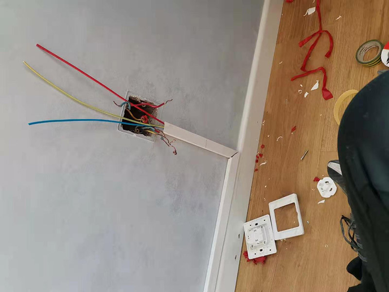 客廳明裝電路維修：從起始端到終結端，先干線支線找好水平線和垂直線。用粉線袋在線路中心彈線，并分均檔距，確定固定點位置。在固定點位置處用電錘鉆孔，然后埋入塑料脹管或傘型螺栓，供線槽固定。根據(jù)放置電線的截面大小及根數(shù)，選用適當規(guī)格的線槽。 將線槽的底板橫平豎直地緊貼房屋墻壁、頂面的表面。固定線槽時，一般先固定兩端再固定中間。線槽對接縫與槽蓋對接縫應錯開并不小于10cm。槽底、槽蓋與各種附件相對接時，接縫處應嚴密平整，固定牢固。盒子都應兩點固定，各種附件角、轉角、三通等固定點不應少于兩點。在線路分支接頭處應采用相應的接線箱。