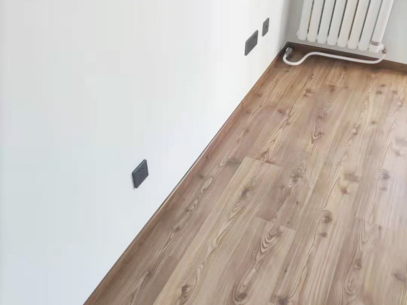 客廳墻面地板翻新：木地板鋪設(shè)之前，要先確保地面平整，然后在地上鋪一層塑料棉膜，塑料棉膜是為了防止地面防潮使木地板變形，接著講木地板都放置在地膜上，這樣在鋪貼的時候比較方便。先確定好木地板鋪設(shè)的方法，確定好之后就可以開始鋪設(shè)了，一般是從墻角開始鋪設(shè)。當(dāng)首塊板鋪上去，第二塊板就必須接連上。然后板與板之間都有槽與突出的插面，插面進(jìn)去槽里要嚴(yán)絲合縫。具體操作是將一塊木地板長面的插面進(jìn)入到前面板的槽里，用手推板的側(cè)面插面進(jìn)入旁邊地板的槽里，如果有縫隙，那么用專用的錘子輕輕敲到一些即可。