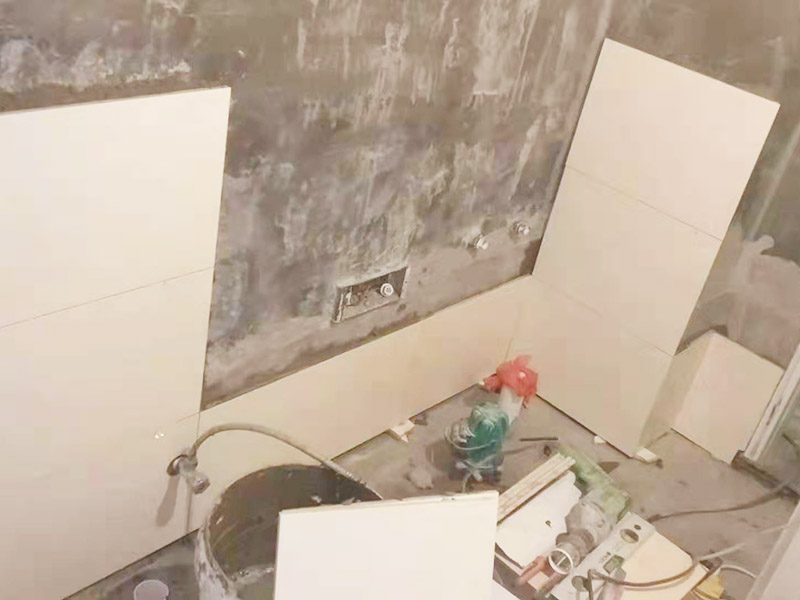 衛(wèi)生間墻面貼磚：首先應(yīng)除去基層表面的污垢，油漬，浮灰;除去基層上所有涂料層，膩?zhàn)訉?如果基層未能達(dá)到平整度要求，需對(duì)基層進(jìn)行預(yù)先的找平處理。鋪貼瓷磚前需事先找好垂直線，以此為基準(zhǔn)鋪貼的瓷磚高低均勻、垂直美觀;此外，施工前在墻體四周需彈出標(biāo)高控制線，在地面彈出十字線，以控制地磚分隔尺寸。對(duì)瓷磚的色彩、紋理、表面平整等進(jìn)行嚴(yán)格的挑選，然后按照?qǐng)D紙要求預(yù)鋪。對(duì)可能出現(xiàn)的尺寸、色彩、紋理誤差等進(jìn)行調(diào)整、交換，直至達(dá)到最佳效果。 調(diào)制粘結(jié)劑：加水后將粘結(jié)劑漿料攪拌至潤(rùn)滑均勻，無(wú)明顯塊狀或糊狀結(jié)塊，攪拌后的漿料靜置5-10分鐘后再稍加攪拌1-2分鐘即可使用。 將瓷磚平整地鋪貼在基層上，使用橡膠錘將瓷磚拍實(shí)鋪平。施工過程中，可小幅度轉(zhuǎn)動(dòng)瓷磚，使?jié){料與瓷磚背面充分接觸。