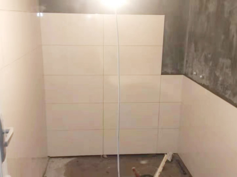 衛(wèi)生間墻面貼磚：首先應(yīng)除去基層表面的污垢，油漬，浮灰;除去基層上所有涂料層，膩?zhàn)訉?如果基層未能達(dá)到平整度要求，需對(duì)基層進(jìn)行預(yù)先的找平處理。鋪貼瓷磚前需事先找好垂直線，以此為基準(zhǔn)鋪貼的瓷磚高低均勻、垂直美觀;此外，施工前在墻體四周需彈出標(biāo)高控制線，在地面彈出十字線，以控制地磚分隔尺寸。對(duì)瓷磚的色彩、紋理、表面平整等進(jìn)行嚴(yán)格的挑選，然后按照?qǐng)D紙要求預(yù)鋪。對(duì)可能出現(xiàn)的尺寸、色彩、紋理誤差等進(jìn)行調(diào)整、交換，直至達(dá)到最佳效果。 調(diào)制粘結(jié)劑：加水后將粘結(jié)劑漿料攪拌至潤(rùn)滑均勻，無(wú)明顯塊狀或糊狀結(jié)塊，攪拌后的漿料靜置5-10分鐘后再稍加攪拌1-2分鐘即可使用。 將瓷磚平整地鋪貼在基層上，使用橡膠錘將瓷磚拍實(shí)鋪平。施工過程中，可小幅度轉(zhuǎn)動(dòng)瓷磚，使?jié){料與瓷磚背面充分接觸。