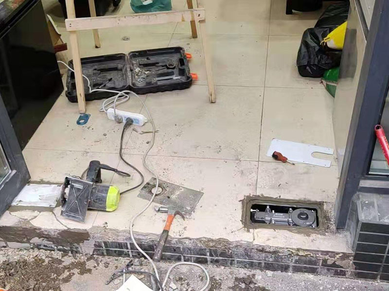 感應(yīng)門(mén)安裝維修：首先移動(dòng)門(mén)體確定門(mén)體的開(kāi)閉位置，然后確定限位器的位置。設(shè)定限位器裝置的位置時(shí)，應(yīng)使吊掛裝置碰到限位器的膠墊后停止。用六角扳手確實(shí)擰緊固定安裝螺栓。 地輪的安裝，在安裝時(shí)地輪的中心位置根據(jù)門(mén)體動(dòng)扇寬度的一半加上5mm。(前提為動(dòng)扇底部?jī)?nèi)有滑道的，如果沒(méi)有滑道直接是包飾板的應(yīng)考慮其在內(nèi)部的空間距離，根據(jù)實(shí)際來(lái)計(jì)算)安裝后請(qǐng)確保門(mén)體上下縫隙相同，以免時(shí)間長(zhǎng)損壞地輪。