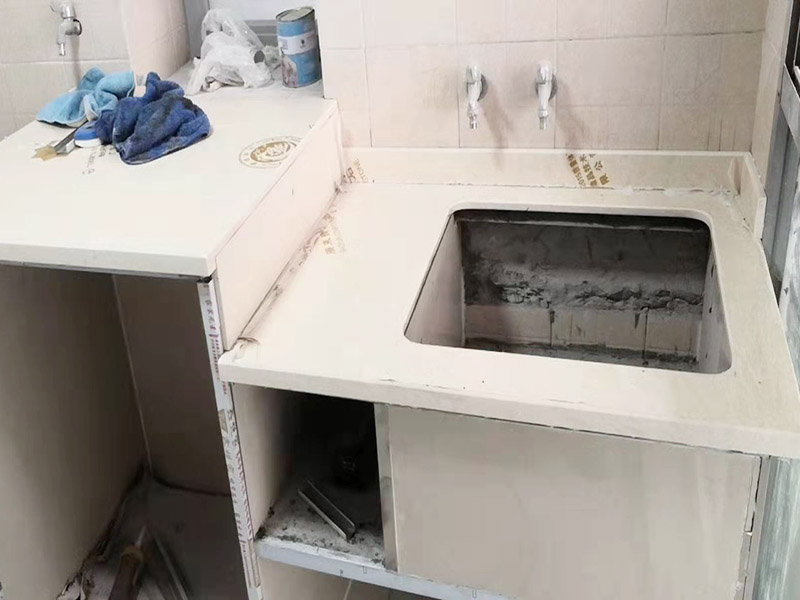 磚砌櫥柜施工：磚砌櫥柜相對(duì)于集成櫥柜來(lái)說(shuō)，磚砌櫥柜使用到的材料大多數(shù)都是無(wú)污染的原材料，它的環(huán)保系數(shù)還是可以的。磚砌櫥柜比較經(jīng)濟(jì)耐用，它的質(zhì)地比較結(jié)實(shí)，隨隨便便應(yīng)該是損壞不了的，即使長(zhǎng)期的做菜做飯動(dòng)靜很大，也不至于直接會(huì)損壞櫥柜。 1.先砌好櫥柜底座或背墻磚，貼好踢腳線邊條。 2.預(yù)留好立柱位置，貼櫥柜底面磚和背墻。 3.制作立柱。 4.站立好立柱后，在槽里加上砂漿，底面槽內(nèi)外端用一小塊?；u墊上，墊的時(shí)候這塊小磚直接與地層的邊磚接觸，保持厚度2公分左右。 5.臺(tái)面放鋼筯和澆筑混凝土。澆筑完成后，安裝臺(tái)面和柜門(mén)。臺(tái)面可以采用大理石、石英石或者玻化磚。