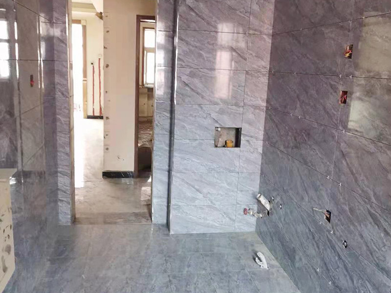 全屋瓷磚鋪貼：首先應(yīng)除去基層表面的污垢，油漬，浮灰;除去基層上所有涂料層，膩子層;如果基層未能達(dá)到平整度要求，需對基層進(jìn)行預(yù)先的找平處理。鋪貼瓷磚前需事先找好垂直線，以此為基準(zhǔn)鋪貼的瓷磚高低均勻、垂直美觀;此外，施工前在墻體四周需彈出標(biāo)高控制線，在地面彈出十字線，以控制地磚分隔尺寸。加水后將粘結(jié)劑漿料攪拌至潤滑均勻，無明顯塊狀或糊狀結(jié)塊，攪拌后的漿料靜置5-10分鐘后再稍加攪拌1-2分鐘即可使用。將瓷磚平整地鋪貼在基層上，使用橡膠錘將瓷磚拍實鋪平。施工過程中，可小幅度轉(zhuǎn)動瓷磚，使?jié){料與瓷磚背面充分接觸。