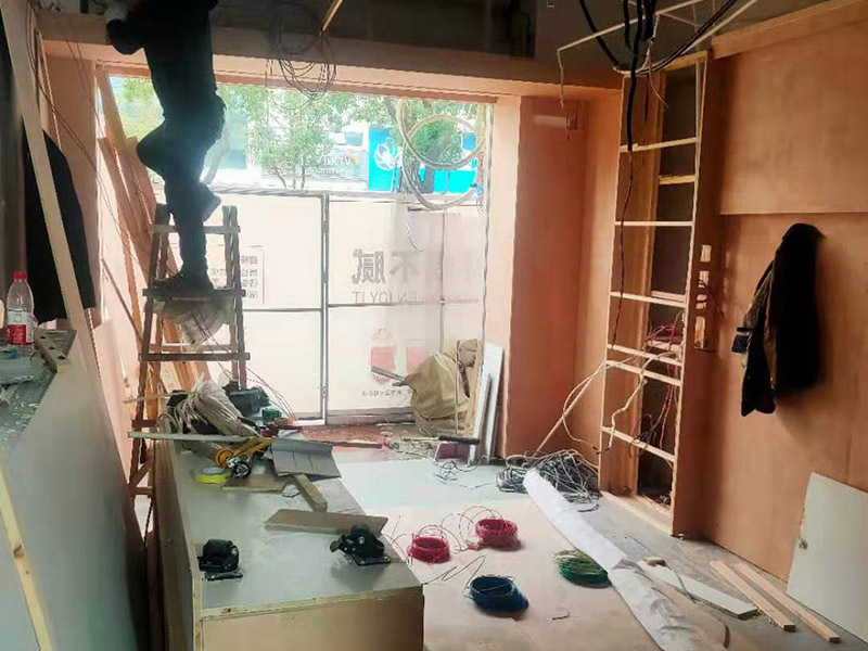 門店木工施工現(xiàn)場:首先應(yīng)該搭建木作施工臺。木作施工臺用于板材的切割板，板材的造型，板材的平整度處理等等。門窗的制作包括門窗套制作、門窗制作。要特別注意門窗扇與框之間的縫隙不能太大，以及門窗套與門窗的色差等。木作表層封裝木制品制作完成后，對其表面進行細節(jié)封裝。木作表層封裝通常就要用到各種各樣的家裝板材，特別注意板材的選購。