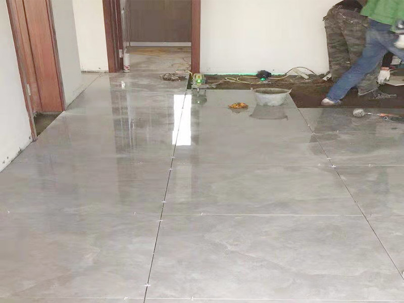 客廳地面貼磚：首先要把基層用水澆濕，除去雜物和浮沙。再抹結(jié)合層，需要注意的是要使用1：3的干性水泥漿，按照水平線探鋪平整，然后再把磚放在沙漿上用膠皮錘振實(shí)。這時(shí)再把地面磚取下澆抹水泥漿，然后把地面磚放實(shí)振平就可以了。采用干鋪法可以有效地避免鋪裝過程中造成的空鼓、氣泡等現(xiàn)象發(fā)生。但是干鋪法的技術(shù)含量比較高，所以費(fèi)用也會(huì)比較貴。