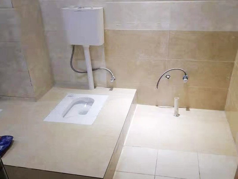 蹲便器安裝貼磚裝修：1.根據(jù)所安裝產(chǎn)品的排污口，在離墻適當(dāng)?shù)奈恢妙A(yù)留下水管道，同時(shí)確定下水管道入口距地平面的距離。 2.在地面下預(yù)留安裝蹲便器的凹坑深度大于便器的高度。 3.將連接膠塞放入蹲便器的進(jìn)水孔內(nèi)卡緊。在與蹲便器進(jìn)水孔接觸的外邊緣涂上一層玻璃膠或油灰，將進(jìn)水管插入膠塞進(jìn)水孔內(nèi)，使其與膠塞密封良好，以防漏水。 4.在蹲便器的出水口的邊緣涂上一層玻璃膠或油灰，放入下水管道的入口旋合，用焦渣或其它填充物將便器架設(shè)水平。 5.打開進(jìn)水系統(tǒng)，檢查各接合處有無漏水情況，若出現(xiàn)漏水，則要檢查各接合處的情況。直至問題解決。 6.檢查各接合處無漏水情況后，用填充物將便器周圍填實(shí)，同時(shí)陶瓷與水泥砂漿的接觸面填上 1cm 以上的瀝青或油氈等彈性材料。 7.用水泥砂漿將蹲便器固定在水平面內(nèi)，平穩(wěn)、牢固后，然后在水泥面上鋪貼衛(wèi)生間地磚。 8.試沖水，若無異常即可使用。