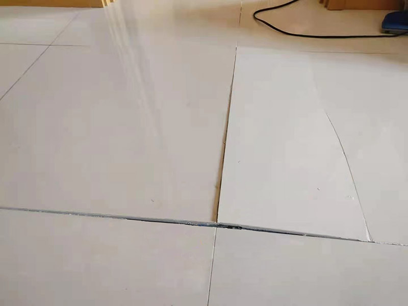 客廳地磚起翹修復：將油灰刀的邊緣滑入松散的瓷磚與其旁邊的瓷磚之間的接縫中。撬起瓷磚并將其移除。用金屬刮刀或小的撬桿的平坦邊緣刮掉基材和瓷磚背面的稀釋劑或瓷磚粘合劑。用相同的工具刮擦周圍空間的舊水泥漿。用清水沖洗除去翹起的瓷磚，然后用濕海綿擦拭，使其干凈。將砂漿抹在缺口邊緣上，然后將稀釋水泥砂漿抹在瓷磚的背面，將瓷磚鋪回原位。如果難以將瓷磚平整，則將瓷磚墊片插入接縫或修補物與包圍它的瓷磚之間的接縫或接縫中。刮掉多余的漿液，并讓該區(qū)域靜置約10分鐘。用水蘸軟海綿，然后輕輕擦拭修復區(qū)域。瓷磚上出現(xiàn)一層干粉后，請用干抹布擦拭。