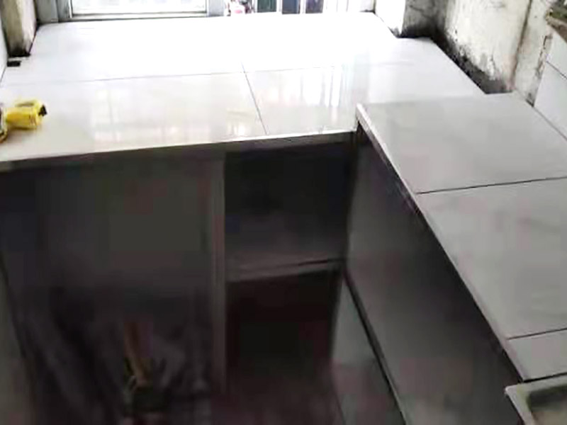 廚房磚砌櫥柜：櫥柜的水電定位時，先劃分功能區(qū)：洗菜盆區(qū)、灶臺區(qū)、切菜區(qū)、電器區(qū)，把這些區(qū)域的具體尺寸畫在墻面上，安排好進水管、排水管和各種插座的準確位置。 磚砌櫥柜制作的時候先做櫥柜的圍角，可以根據(jù)自己的喜好選擇不同顏色的瓷磚來實現(xiàn)。圍角完成以后的重要工作就是用水泥和砂漿將櫥柜的底部填實，上面鋪瓷磚。同時，瓷磚豎隔板的位置按照櫥柜圖紙進行預留。 磚砌櫥柜制作好之后，我們可以根據(jù)自己喜歡的風格選擇不同材質(zhì)的石材臺面和門板，完全不影響美觀，同時對于櫥柜內(nèi)部我們均采用不銹鋼條進行收邊，既美觀又好打掃衛(wèi)生。