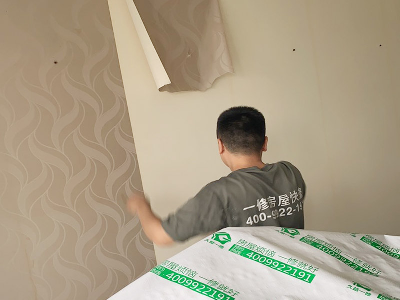 客廳墻面墻紙鏟除：盡量貼近墻面，捏住墻紙的一角，試著將其從墻面上揭下。朝著自己的方向?qū)垊冸x墻面，這樣更容易揭下墻紙。如果不容易撕的話，可以在墻面滾刷一些肥皂水，然后用美工刀、剃刀片或墻紙刮刀，沿水平方向?qū)⑴f墻紙割開，讓溫肥皂水或墻紙剝除劑滲到墻紙的后面，軟化粘合劑，然后就可以從石膏墻上撕除或刮除墻紙了。