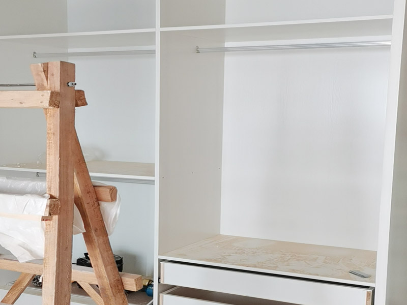 定制衣柜安裝：首先上螺絲將螺絲上到板件上已開好的孔內，螺絲要垂直于板件，螺絲上到剛好與孔面齊平最好。然后根據螺絲位置將板件拼接好，將扣件按入餅孔內旋轉鎖緊，隨后鎖好所有扣件后，需要釘背板的釘好背板，一切好了之后將柜體安放到位，柜體與墻面之間的縫隙用收口條封好。